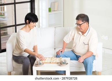 asian senior couple playing chess at home  - Powered by Shutterstock