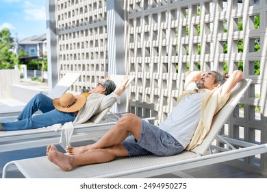 asian senior couple resting tranquility on beach chair at the swimming pool in the resort,elderly people lifestyle travel,relaxation - Powered by Shutterstock