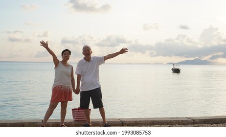 Asian Senior Couple Standing Playing At Beach Sunrise Sea Early Morning Relaxed Happy Natural Retirement