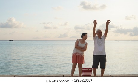 Asian Senior Couple Standing Playing At Beach Sunrise Sea Early Morning Relaxed Happy Natural Retirement