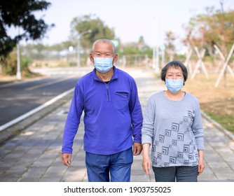 Asian Senior  Couple Wearing Face Mask And Walking On Street