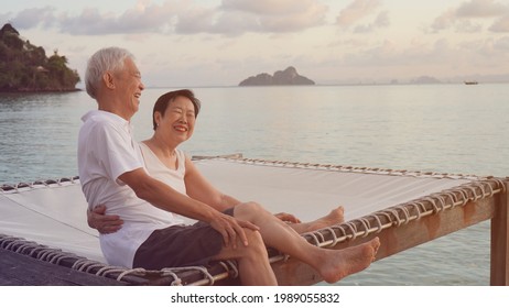 Asian Senior Elder Couple Sitting At Sunrise Sea Early Morning Relaxed Happy Natural Retirement