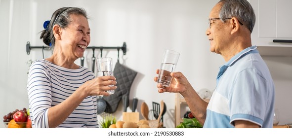 Asian senior elderly couple drink a glass of water in kitchen at home. Mature older thirsty grandparent holding clean mineral natural in cup after waking up and sip in morning for health care in house - Powered by Shutterstock