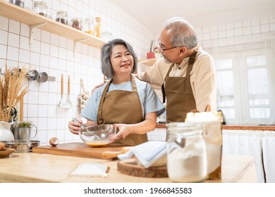 Asian Senior elderly couple standing in kitchen at house feeling happy and enjoy retirement life together. Loving Older grandparent cooking food with smiling face. Relationship and activity at home. - Powered by Shutterstock