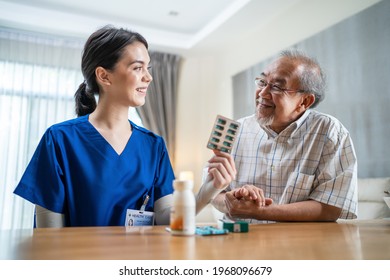 Asian Senior Elderly Male Patient Consult With Physician Nurse At Nursing Home Care. Caregiver Therapist Pharmacist Girl Hold Medicine Pills Bottle, Explain Prescription To Older Disabled Guy In House