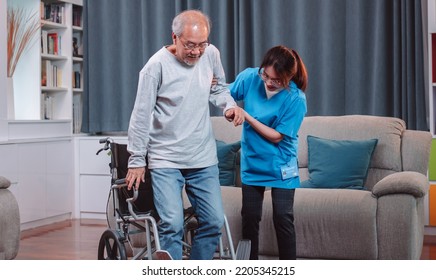 Asian senior elderly man patient doing physical therapy with caregiver. woman nurse helping get up from wheelchair for practice walking at home, practice walking slowly at nursing home care concept. - Powered by Shutterstock