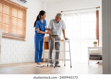 Asian senior elderly man patient doing physical therapy with caregiver. Attractive specialist carer women help and support older mature male practice walking slowly with walker at nursing home care. - Powered by Shutterstock