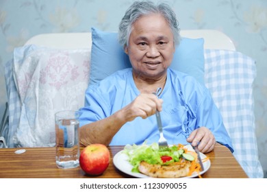 Asian Senior Or Elderly Old Lady Woman Patient Eating Breakfast Healthy Food With Hope And Happy While Sitting And Hungry On Bed In Hospital.
