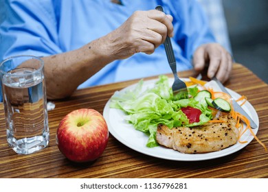 Asian Senior Or Elderly Old Lady Woman Patient Eating Breakfast Healthy Food With Hope And Happy While Sitting And Hungry On Bed In Hospital.
