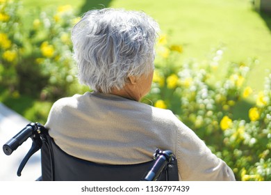 Asian Senior Or Elderly Old Lady Woman Sitting On Wheelchair With Strong Health At Park In Happy Holiday 
     