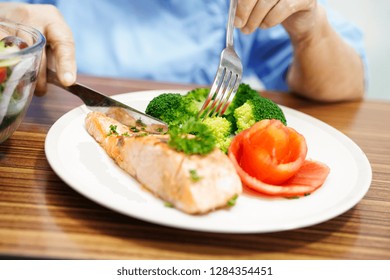 Asian Senior Or Elderly Old Lady Woman Patient Eating Salmon Breakfast Healthy Food With Hope And Happy While Sitting And Hungry On Bed In Hospital.
