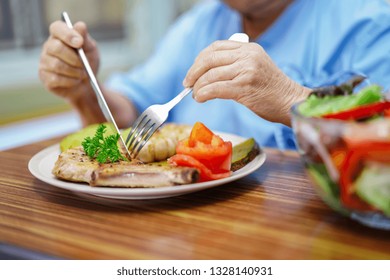 Asian Senior Or Elderly Old Lady Woman Patient Eating Breakfast Healthy Food With Hope And Happy While Sitting And Hungry On Bed In Hospital.
     