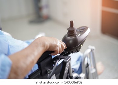 Asian senior or elderly old lady woman patient on electric wheelchair  at nursing hospital 