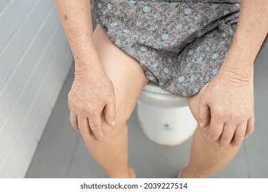 Asian Senior Or Elderly Old Lady Woman Patient Sitting On Flush Toilet In Bathroom.