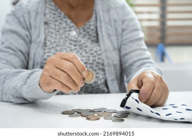 Asian Senior Or Elderly Old Lady Woman Holding Counting Coin Money In Bag. Poverty, Saving Problem In Retirement.