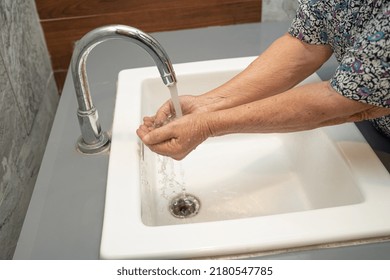 Asian senior or elderly old lady woman patient washing hand by soap and clean water for protect safety infection and kill Coronavirus Covid19 virus, bacteria and germs. - Powered by Shutterstock