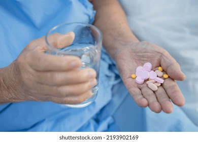 Asian Senior Elderly Old Lady Woman Holding Vitamin Pills Drug In Her Hand, Healthy Strong Medical Concept.