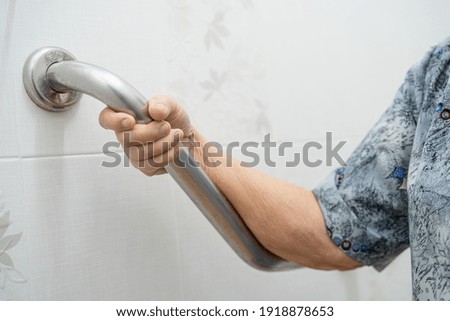 Asian senior or elderly old lady woman patient use toilet bathroom handle security in nursing hospital ward, healthy strong medical concept.  