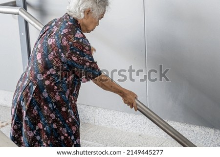 Asian senior or elderly old lady woman patient use handle at stairs security support in building, healthy strong medical concept.