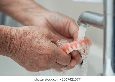 Asian Senior Or Elderly Old Woman Patient Holding And Washing Denture In Nursing Hospital Ward; Healthy Strong Medical Concept