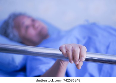 Asian Senior Or Elderly Old Woman Patient Lie Down Handle The Rail Bed With Hope On A Bed In The Hospital.