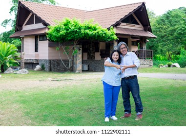asian senior female and asian senior male stand on nature background, husban and his wife feeling happy, they show heart sign in garden, traditional home  - Shutterstock ID 1122902111