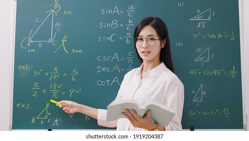 asian senior high school female teacher teach math online through webcam in classroom