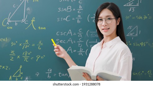 asian senior high school female teacher teach math online through webcam in classroom