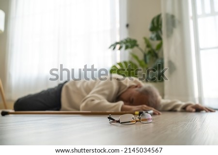 Asian senior male falling on the ground while walk with walker at home. Elderly older mature grandfather having an accident after doing physical therapy alone after retirement in living room in house. Сток-фото © 