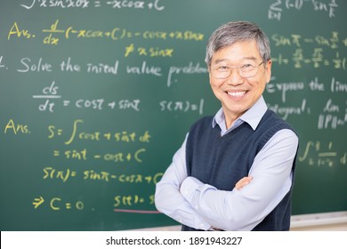 asian senior male professor smile at you in front of blackboard with calculus formula at college classroom