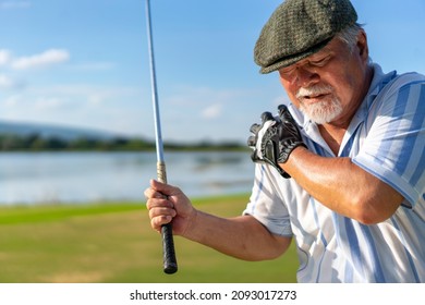 Asian Senior Man Caught Injury Shoulder While Golfing At Country Club On Summer Vacation. Elderly Male Golfer Shoulder Pain While Outdoor Sport Workout. Senior People Medical And Healthy Care Concept