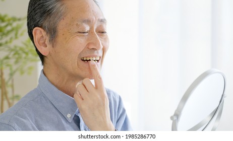 Asian Senior Man Checking Teeth