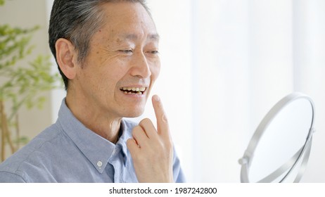 Asian Senior Man Checking Teeth