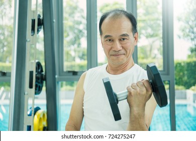 Asian Senior Man Doing Weight Training With Dumbbells At The Gym, Sport Old Man Exercise Work Out At The Gym.