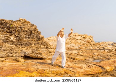 Asian senior man enjoy outdoor lifestyle travel nature on summer holiday vacation. Elderly man do relaxing exercise tai chi, yoga on mountain cliff at sunset. Wellness, health care motivation concept. - Powered by Shutterstock