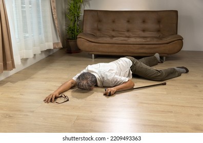 Asian Senior Man Falling Down And Lying On The Floor While Walk With Walking Stick At Home.