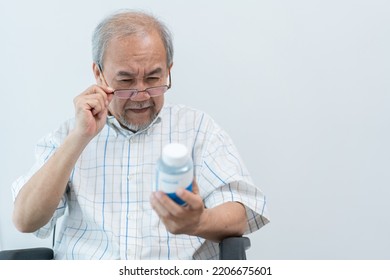 Asian Senior Man With Farsighted Reading Prescription On Medicine Bottle At Nursing Home. Medical Insurance And Health Care Concept