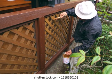 Asian Senior Man Painting Fence Outdoors