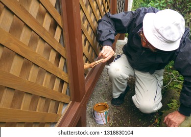 Asian Senior Man Painting Fence Outdoors