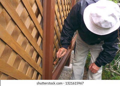 Asian Senior Man Painting Fence Outdoors