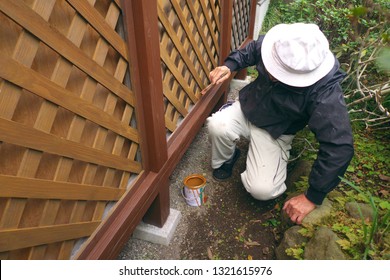 Asian Senior Man Painting Fence Outdoors