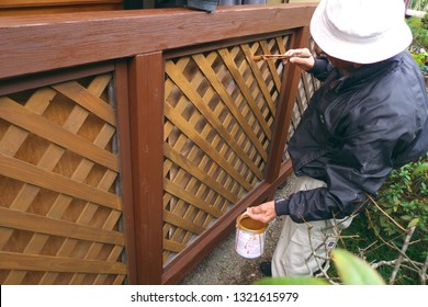 Asian Senior Man Painting Fence Outdoors