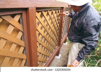 Asian Senior Man Painting Fence Outdoors