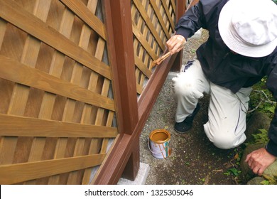 Asian Senior Man Painting Fence Outdoors