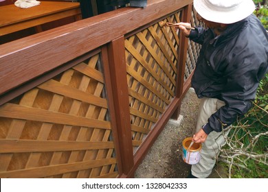 Asian Senior Man Painting Fence Outdoors