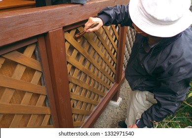 Asian Senior Man Painting Fence Outdoors