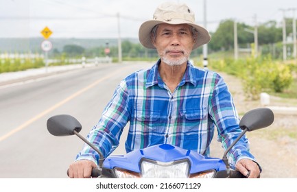 Asian Senior Man Riding A Motorcycle On The Road