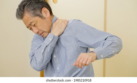 Asian Senior Man With Stiff Shoulders