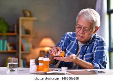 Asian Senior Man Taking Medicine At Home