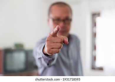 Asian senior man wearing glasses raise his hand to pointing finger displeased and frustrated to the camera. People and upset, angry and furious concept